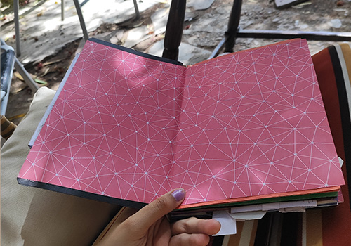 Guarda de la portada, papel rosa atravesadoo por lineas geométricas blancas.